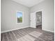 Bright bedroom with grey walls and wood-look flooring, open to another room at 3332 York Hwy, Gastonia, NC 28052