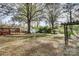 Large backyard with mature trees, sheds, and a wooden pergola at 3632 Wilder Rd, Concord, NC 28025