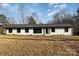 Ranch style home with white brick exterior, dark windows, and a gray roof at 3700 Pinecrest Dr, Gastonia, NC 28056