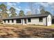 Ranch style home with white brick exterior, dark windows, and a gray roof at 3700 Pinecrest Dr, Gastonia, NC 28056