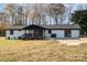Rear view of a renovated house with a white brick exterior and new deck at 3700 Pinecrest Dr, Gastonia, NC 28056