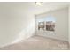 Well-lit bedroom with neutral carpeting and a window at 3950 Rothwood Ln, Harrisburg, NC 28075