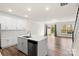 Modern kitchen with white cabinets, island, stainless steel appliances, and hardwood floors at 3950 Rothwood Ln, Harrisburg, NC 28075