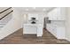Modern kitchen with white cabinets, island, and stainless steel appliances at 3950 Rothwood Ln, Harrisburg, NC 28075