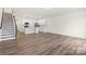 Modern kitchen with white cabinets, island, and hardwood floors at 3950 Rothwood Ln, Harrisburg, NC 28075