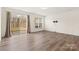 Bright living room featuring hardwood floors and sliding glass doors leading to a patio at 3950 Rothwood Ln, Harrisburg, NC 28075