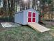 Gray shed with red doors and a wooden ramp at 4541 Hall Dairy Rd, Claremont, NC 28610