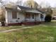 White frame house with boarded windows, needing repairs at 523 Hoyle St, Dallas, NC 28034