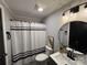 Clean bathroom, featuring a white tile shower, gray vanity, and round mirror at 701 Firecrest Se St, Concord, NC 28025