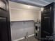 Small laundry closet with shelving and water heater at 701 Firecrest Se St, Concord, NC 28025