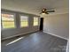 Bright living room with three windows and ceiling fan at 701 Firecrest Se St, Concord, NC 28025