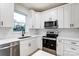 Modern kitchen with white cabinets, stainless steel appliances, and white subway tile backsplash at 7425 Capri Dr, Huntersville, NC 28078