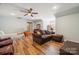 Spacious bonus room with wood floors, a sofa, and a ceiling fan at 9717 Willow Leaf Ln, Cornelius, NC 28031