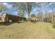 Landscaped backyard with mature trees and partial view of home at 1314 Frederick St, Shelby, NC 28150