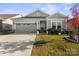 Gray house with two-car garage, landscaping, and a well-maintained lawn at 9299 Dunwich Dr, Gastonia, NC 28056