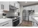 Modern kitchen with white cabinets, stainless steel appliances, and gray herringbone backsplash at 1132 Ryan Meadow Dr, Monroe, NC 28110