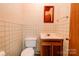 Small basement bathroom with a toilet, sink, and tiled walls at 608 Hanover Dr, Shelby, NC 28150