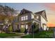 Two-story house with front porch, landscaping, and brick accents at dusk at 1002 Trigger Dr, Indian Trail, NC 28079