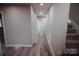 Bright hallway with wood-look flooring and access to stairs at 115 Joels Hill Ln, Mooresville, NC 28117