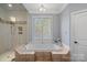 Bathroom with soaking tub, glass shower, and neutral color palette at 18912 Peninsula Point Dr, Cornelius, NC 28031