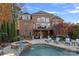 Brick home with a large deck, pool, and lush landscaping at 18912 Peninsula Point Dr, Cornelius, NC 28031