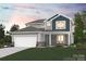 Two-story house with gray and blue siding, stone accents, and a two-car garage at 201 E Warfield Dr, Mooresville, NC 28115