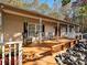 Large front porch with rocking chairs, a wooden deck, and stone accents at 25040 Timberlake Dr, Tega Cay, SC 29708