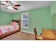 A light green bedroom with a bed, desk, and window with blinds at 37443 Melton Rd, Albemarle, NC 28001