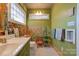 Bathroom with green vanity, floral wallpaper and patterned floor at 600 W Warren St, Shelby, NC 28150