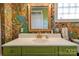 Unique bathroom with floral wallpaper, green vanity, and gold fixtures at 600 W Warren St, Shelby, NC 28150