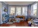 Sunroom with multiple windows, wooden floors, and various furniture and supplies at 600 W Warren St, Shelby, NC 28150