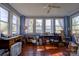 Sunroom with multiple windows, wooden floors, and various furniture and supplies at 600 W Warren St, Shelby, NC 28150