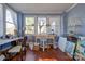 Sunroom with multiple windows, wooden floors, and various furniture and supplies at 600 W Warren St, Shelby, NC 28150