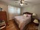 Charming bedroom with hardwood floors, ceiling fan, and a lovely bed at 7855 Nc Highway 90 E None, Stony Point, NC 28678