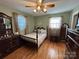 Spacious bedroom with hardwood floors, ceiling fan, and dark wood furniture at 7855 Nc Highway 90 E E None, Stony Point, NC 28678