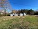 Four storage sheds in a grassy backyard setting at 7855 Nc Highway 90 E None, Stony Point, NC 28678