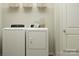 Bright laundry room with washer, dryer, and shelving at 1165 Blackburn Cir, Edgemoor, SC 29712