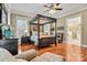 Spacious bedroom with a four-poster bed, hardwood floors, and ensuite bathroom access at 1727 Will Schronce Rd, Lincolnton, NC 28092