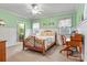 Bedroom with wooden bed frame, desk, and light green walls at 1727 Will Schronce Rd, Lincolnton, NC 28092