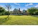 Brick house with a wrap-around porch, showcasing a beautiful front yard at 1727 Will Schronce Rd, Lincolnton, NC 28092