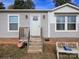 Front entrance of a manufactured home with brick base, wooden steps, and porch at 250 Buckshot Trl, Salisbury, NC 28146