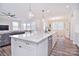 Open kitchen with large island, white cabinets and hardwood floors at 3516 Marchers Trace Dr, Mint Hill, NC 28227