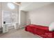 Bright bedroom with a red bed, desk and window at 9039 J M Keynes Dr # 19, Charlotte, NC 28262