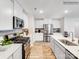 Modern kitchen island with white cabinets, quartz countertops and a stainless steel sink at 112 Mountain Bridge Way, Statesville, NC 28625