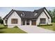 White brick home with dark gray roof, brown garage door, and landscaping at 150A Lookout Dam Rd, Statesville, NC 28625