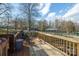 Back deck with wooden railing, two chairs, and storage bin, overlooking fenced yard at 3842 22Nd Street Ne Ct, Hickory, NC 28601