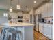 Large kitchen island with seating, stainless steel appliances, and hardwood floors at 123 Dogwood Grove Pl, Troutman, NC 28166