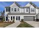 Modern two-story townhome with gray garage doors and landscaping at 2105 Bayou Trace Dr, Charlotte, NC 28262