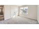 Bright bedroom with gray carpet, double-door closet, and a window with a view at 223 Hamptons Cove Rd, Troutman, NC 28166