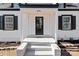 Elegant black front door with a welcoming porch and brick steps at 425 N 5Th St, Albemarle, NC 28001